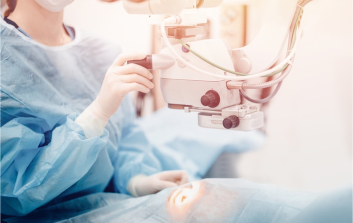 An optometrist examining a patient's eyes with specialized equipment.