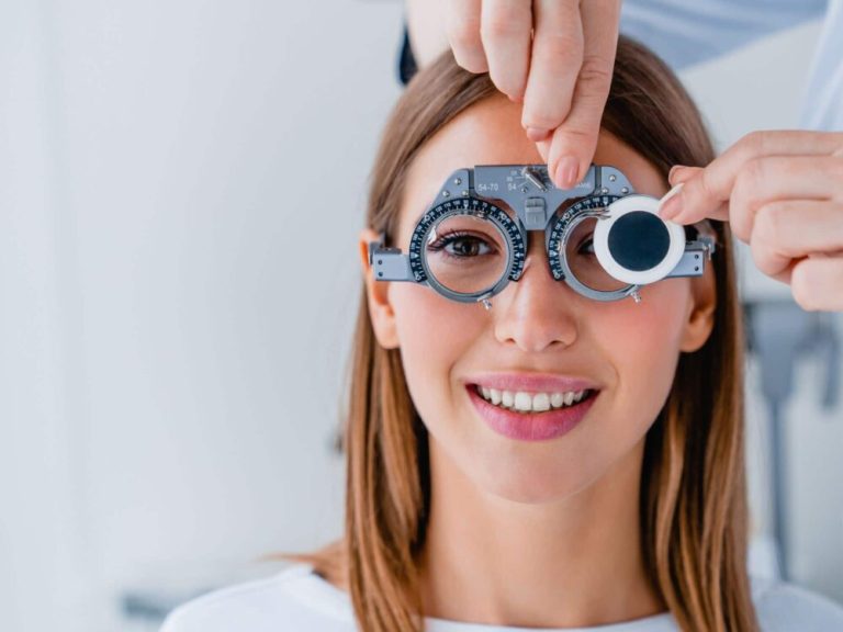 College student contemplating LASIK surgery, holding eyeglasses.